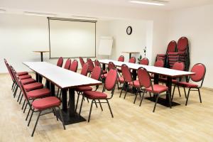 a conference room with tables and chairs and a whiteboard at Resort Hulín in Sedlčany +72 photos