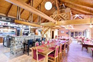 a restaurant with wooden tables and chairs and a bar at Resort Hulín in Sedlčany