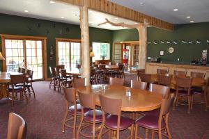 uma sala de jantar com mesas e cadeiras num restaurante em Crooked River Lodge em Alanson