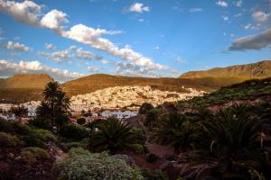 a city in the mountains with palm trees and buildings at Casa Lola in Agaete