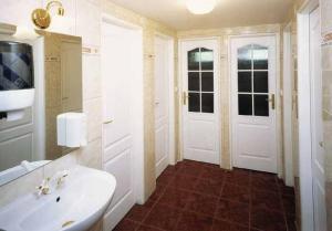 a bathroom with a white sink and two doors at Hotel Hromovka in Špindlerův Mlýn