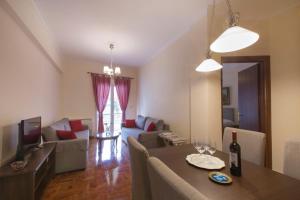 - un salon avec une table et un canapé dans l'établissement Keramikos Cozy Apartment, à Athènes