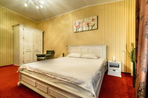 een slaapkamer met een groot wit bed en een stoel bij Vila Sia in Boekarest