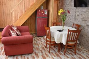 a dining room with a table and a chair and a refrigerator at Cabaña Doña Maria in Puerto Natales