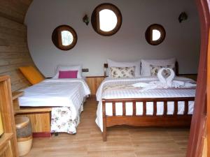 two beds in a room with two windows at Kiri Pura Resort in Phetchabun