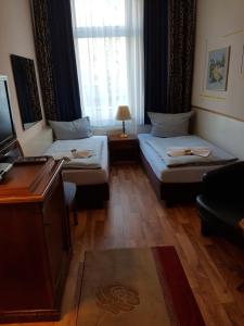 ein Hotelzimmer mit 2 Betten und einem Fenster in der Unterkunft Pension Oase in Berlin