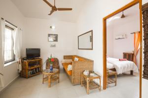 a living room with a bed and a mirror at Tobias Villas in Cavelossim