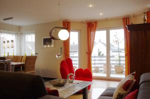 a living room with red chairs and a table at Luxury-Apartment Peter in Bonn