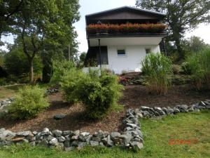 een huis met een bloementuin ervoor bij Ferienhaus im Ederbergland in Hatzfeld