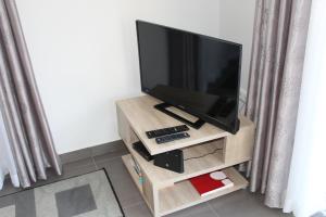 a flat screen tv on a wooden stand in a room at Hills and Atlantic Ocean retreat - Conceição House in Calheta