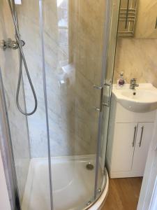 a bathroom with a shower and a sink at The White Hart pub and rooms in Cranleigh