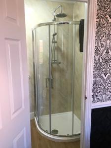 a shower with a glass door in a bathroom at The White Hart pub and rooms in Cranleigh