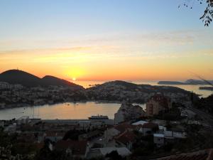 a view of a city with the sun setting over the water at House Smajić in Dubrovnik