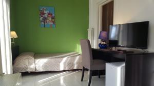 a bedroom with a desk with a television and a bed at Hotel Sauro in Viareggio