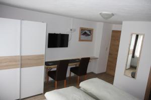 a bedroom with a desk and a bed and a tv at Haus Eckhart in Kaunertal