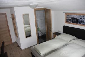 a bedroom with a bed and a bathroom with a mirror at Haus Eckhart in Kaunertal