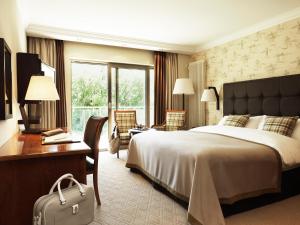 a hotel room with a bed and a desk and chair at The Europe Hotel & Resort in Killarney