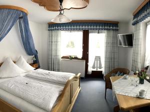a bedroom with a bed and a table with a dining room at Gästehaus Pointner in Ruhpolding
