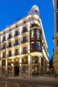 a large white building on a city street at night at Vincci Palace in Valencia