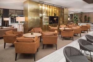 a restaurant with tables and chairs and a lobby at Melia Madrid Serrano in Madrid