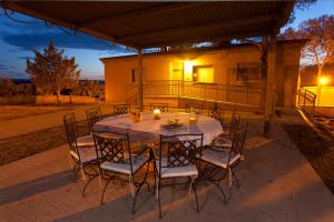 una mesa y sillas en un patio por la noche en RuralSuite Hotel Apartamentos, en Cascante