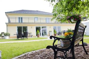 a park bench in front of a house at Pension Casamia in Spremberg