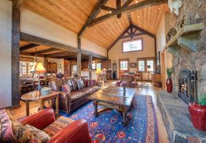 a living room with leather furniture and a stone fireplace at Antler Ridge Lodge in Big Sky