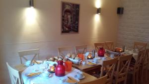 una sala da pranzo con tavoli e sedie con cibo sopra di Gaestehaus Gaes a Trittenheim Altre 13 foto
