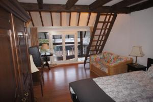 een slaapkamer met een bed en een kamer met een ladder bij apartements Stegelshof in Eygelshoven