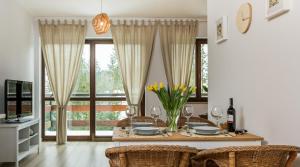 a dining room with a table with yellow flowers on it at TWOJA CHATA Apartament pod lasem in Kościelisko