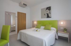una camera con un letto con una parete verde di Hotel Solemare - Frontemare - 3 Stelle Superior a Lido di Jesolo