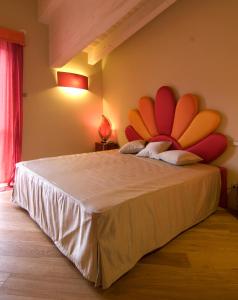 a bedroom with a large bed with a large headboard at Malpassuti Resort in Carbonara Scrivia