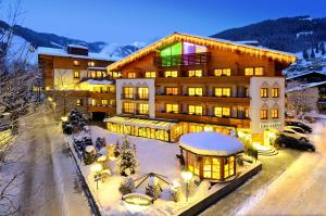 un grande edificio con neve sul terreno di Superior Hotel Tirolerhof - Zell am See a Zell am See