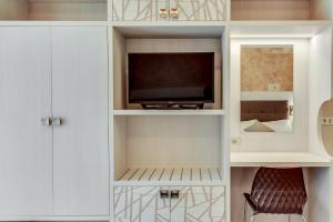 a living room with a tv in a white cabinet at Hotel Dolcevita in Cesenatico