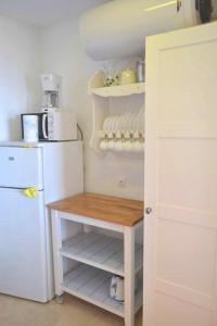 ネルハにあるStudio Marina II Nerjaのキッチン(白い冷蔵庫、木製テーブル付)