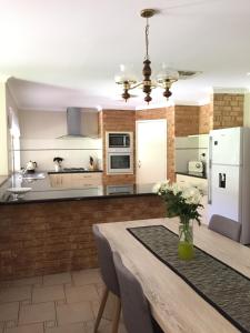 a kitchen with a table and a white refrigerator at Murdoch Station Bed & Breakfast in Perth