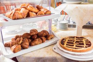a table topped with trays of bread and pastries at Hotel Dolcevita in Cesenatico
