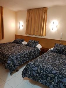 Habitación de hotel con 2 camas y ventana en Hotel Arinsal en Arinsal