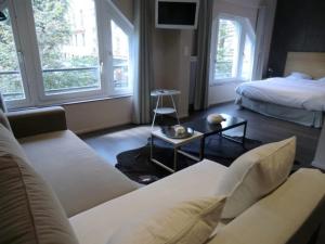 a hotel room with a couch and a bed at Les Carmes in Rouen