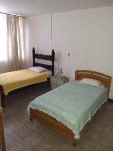 a bedroom with two beds and a window at Alcobas cerca al Éxito San Fernando in Cali