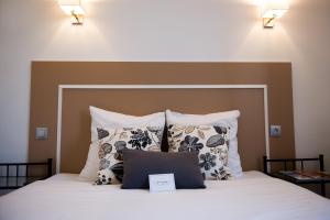 a bedroom with a large bed with pillows at Hôtel Le Stanislas in Nancy