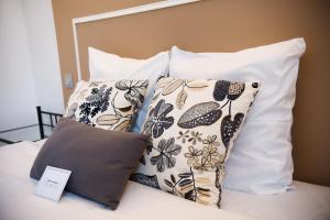 a group of pillows sitting on top of a bed at Hôtel Le Stanislas in Nancy