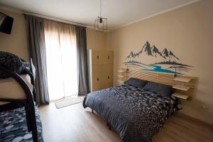 a bedroom with a bed with a mountain mural on the wall at Snowake House in Castel di Sangro