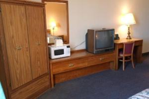 a hotel room with a television and a microwave on a dresser at State Line Inn in Hagerstown