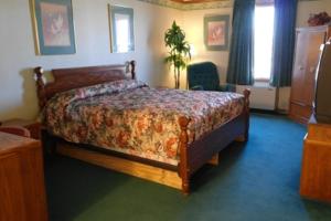 1 dormitorio con 1 cama con colcha de flores en State Line Inn en Hagerstown