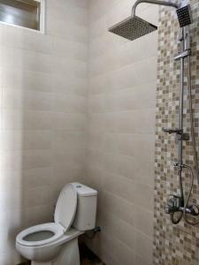 La salle de bains est pourvue d'une douche et de toilettes. dans l'établissement Villa Keluarga Batu, à Batu