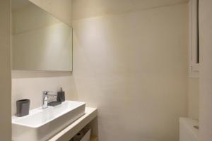 a white bathroom with a sink and a mirror at Apollo Apartment @ Plaka in Athens