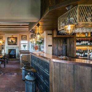 a bar in a restaurant with a table and chairs at The Cow Dalbury in Dalbury Lees