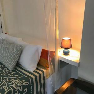 a bedroom with a bed with a lamp on a table at La Maison Blanche in Assinie