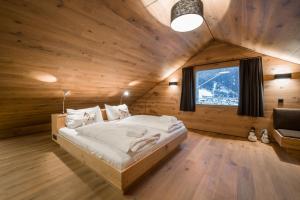 a bedroom with a large bed in a wooden room at Smaragdjuwel in Bramberg am Wildkogel